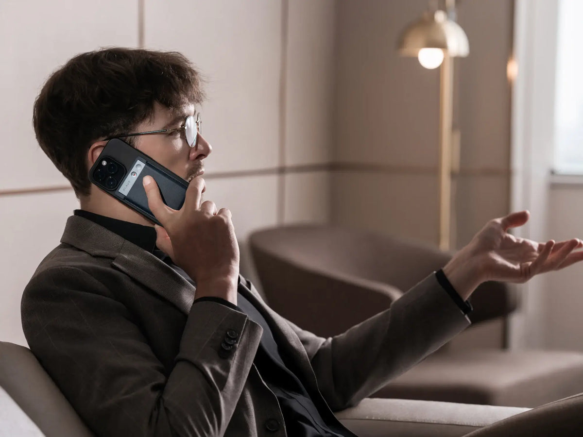 Professional recording a call with a Plaud Note AI voice recorder attached to his smartphone.