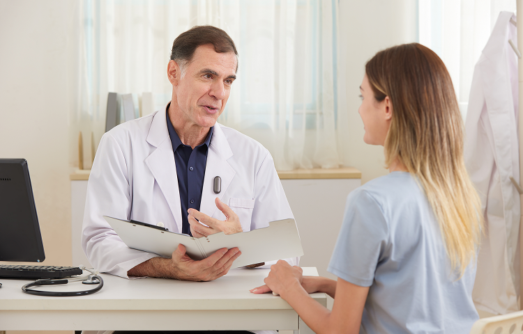 Doctor wearing a Plaud NotePin on his lapel during a consultation with a patient.