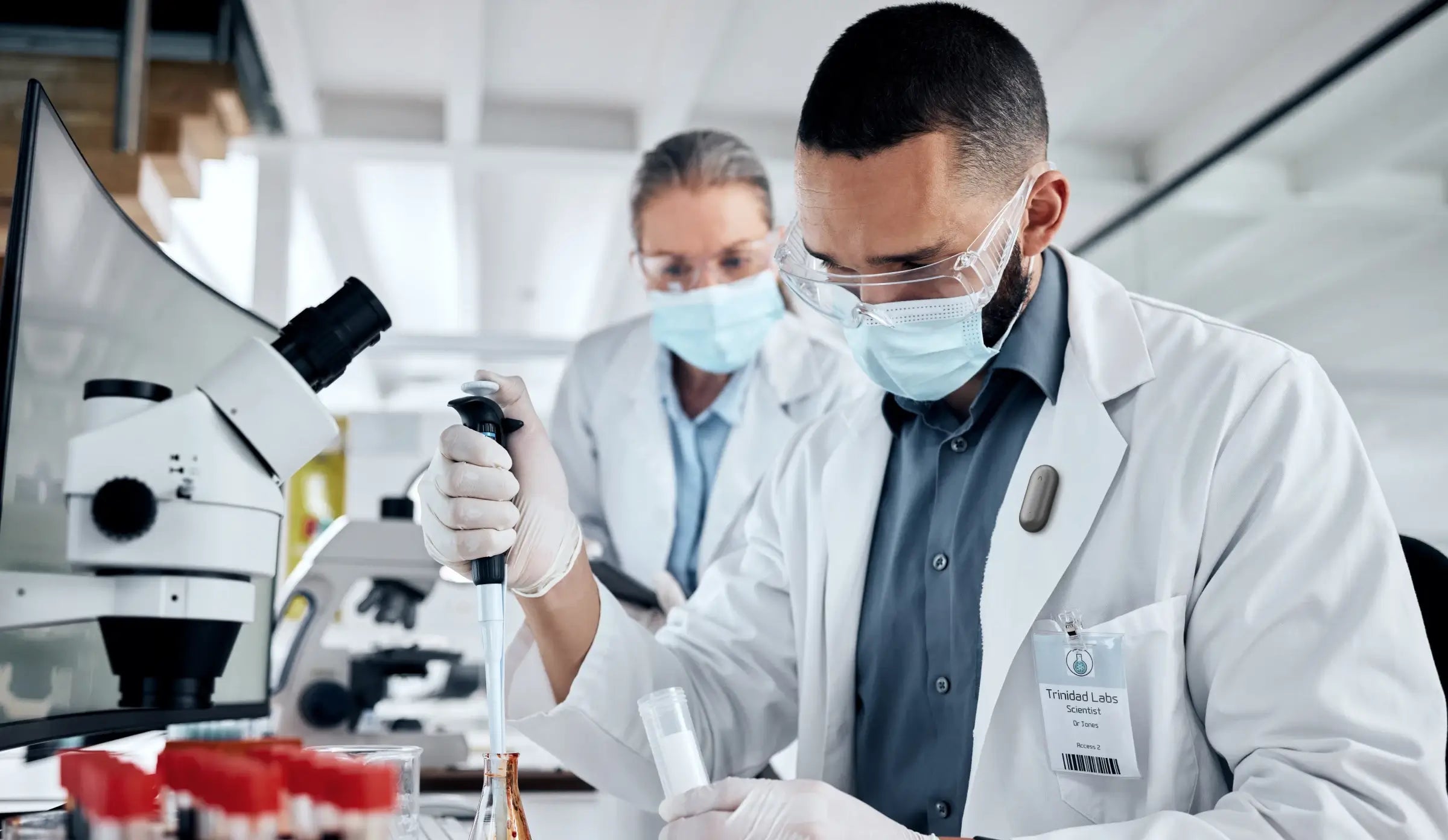A researcher wearing the Plaud NotePin AI voice recorder while working in a laboratory setting.