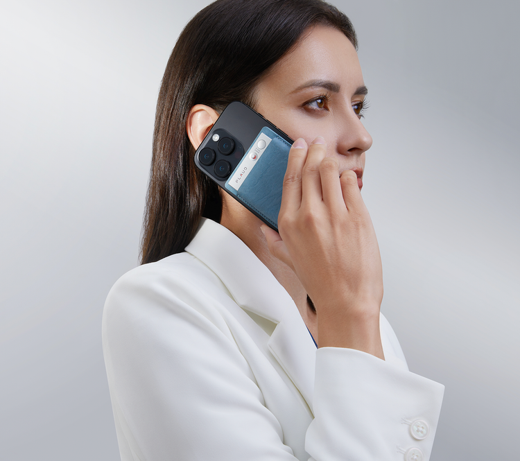 A woman records a phone call using the Plaud Note AI voice recorder attached to her smartphone.