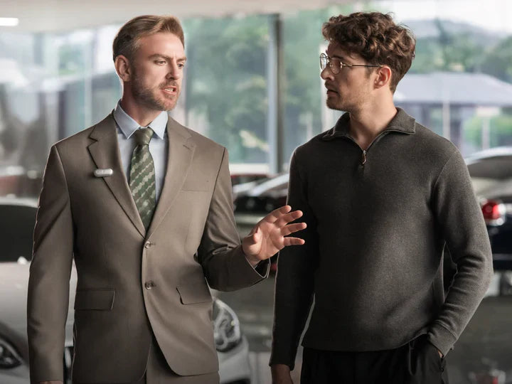 A professional wearing a Plaud NotePin on his lapel while talking to a client in a showroom.