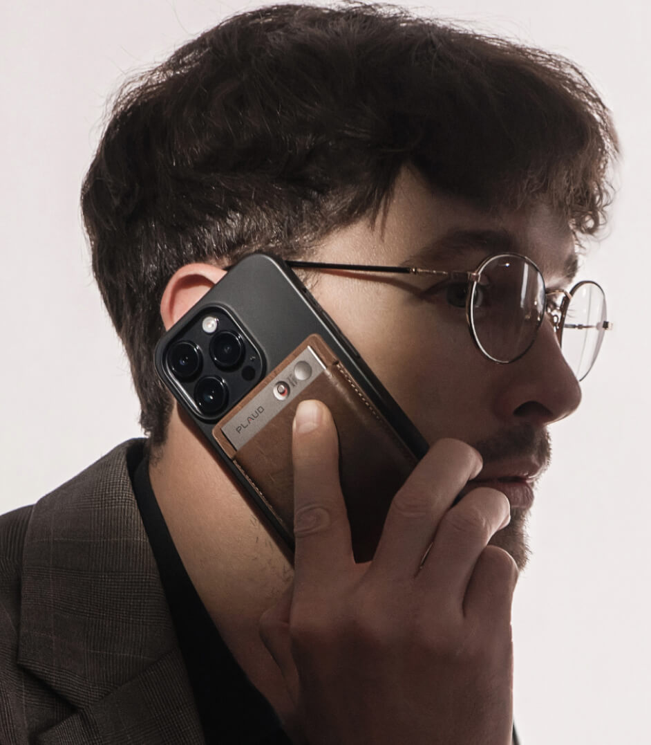 Man using a Plaud Note AI voice recorder attached to his phone to record a call.