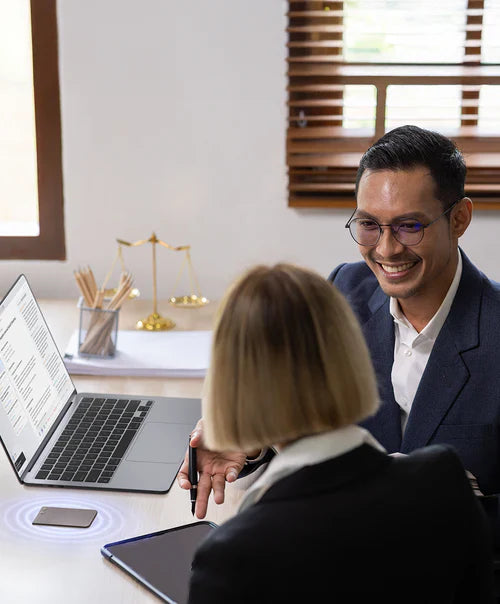A PLAUD NOTE AI voice recorder captures a professional meeting between two colleagues in an office.