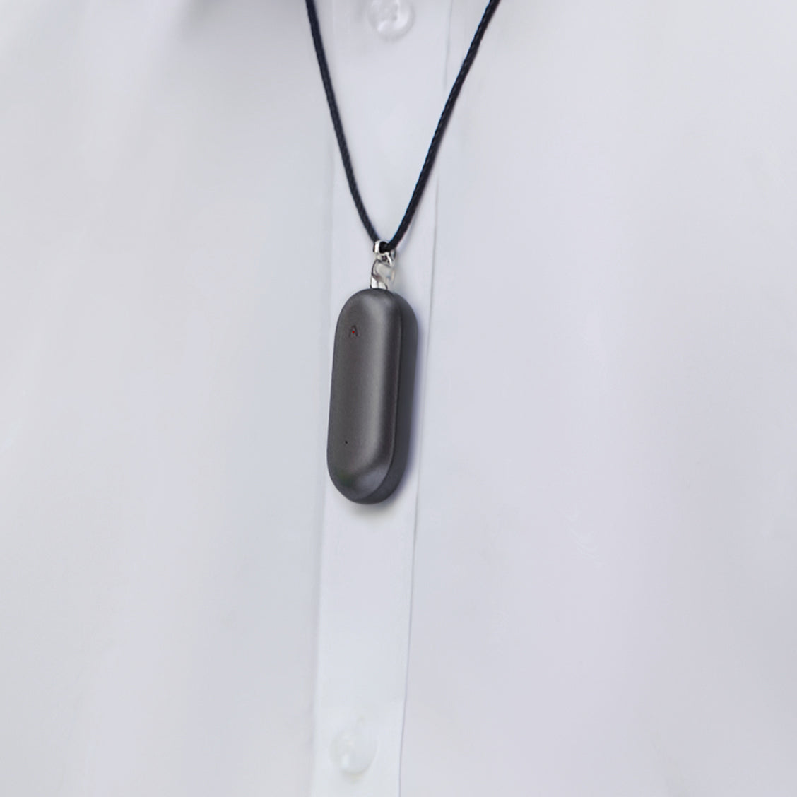 Plaud NotePin AI voice recorder worn as a necklace over a white shirt.