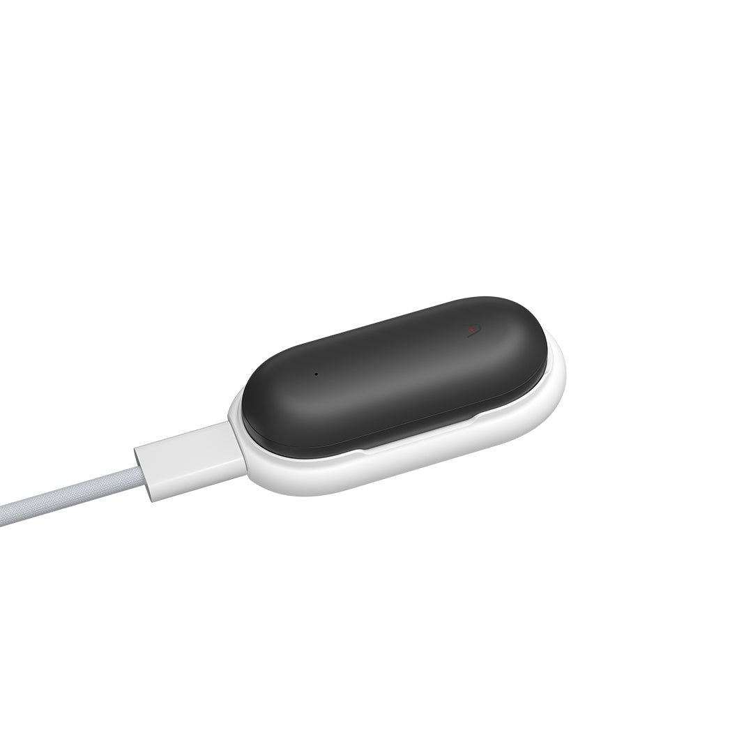 Black Plaud NotePin AI voice recorder charging in its white magnetic dock.