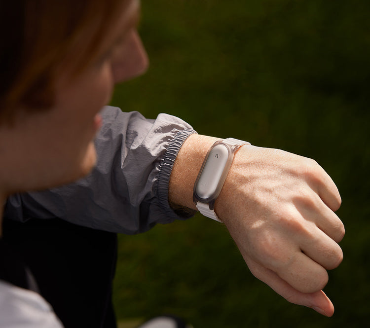 A person wearing the Plaud NotePin AI voice recorder on their wrist using a watch-style strap.