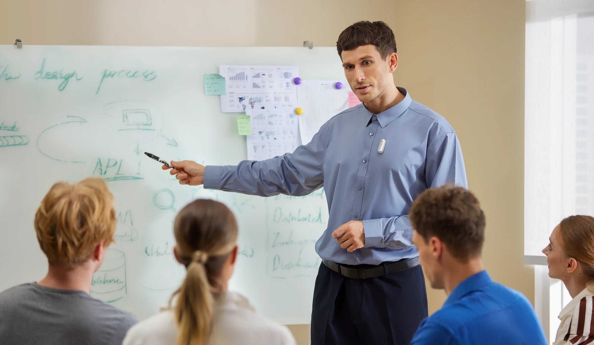 A professional wearing a Plaud NotePin while presenting to a group in front of a whiteboard.