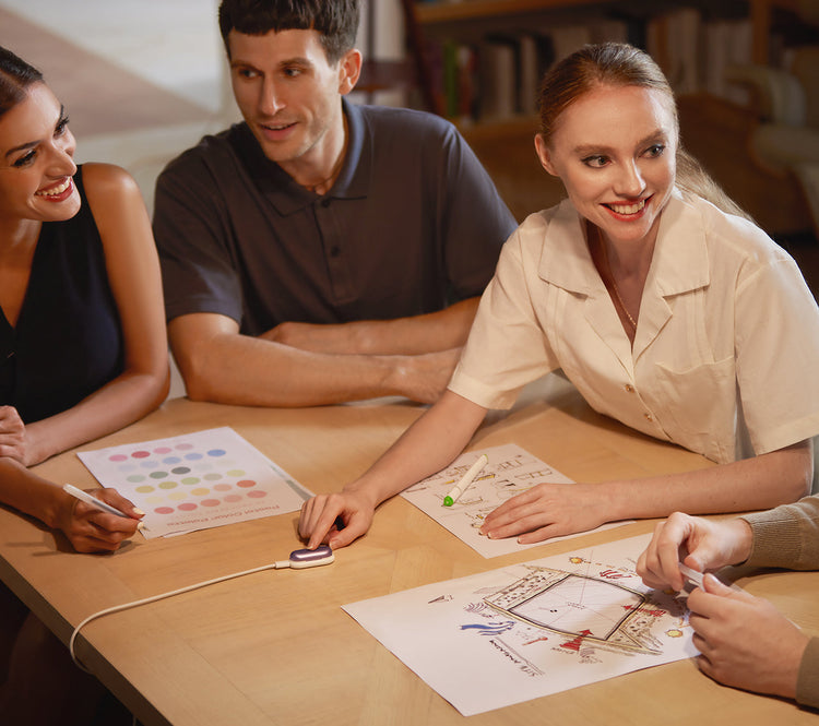 Three colleagues collaborate around a table as one woman activates a Plaud NotePin to record the meeting.