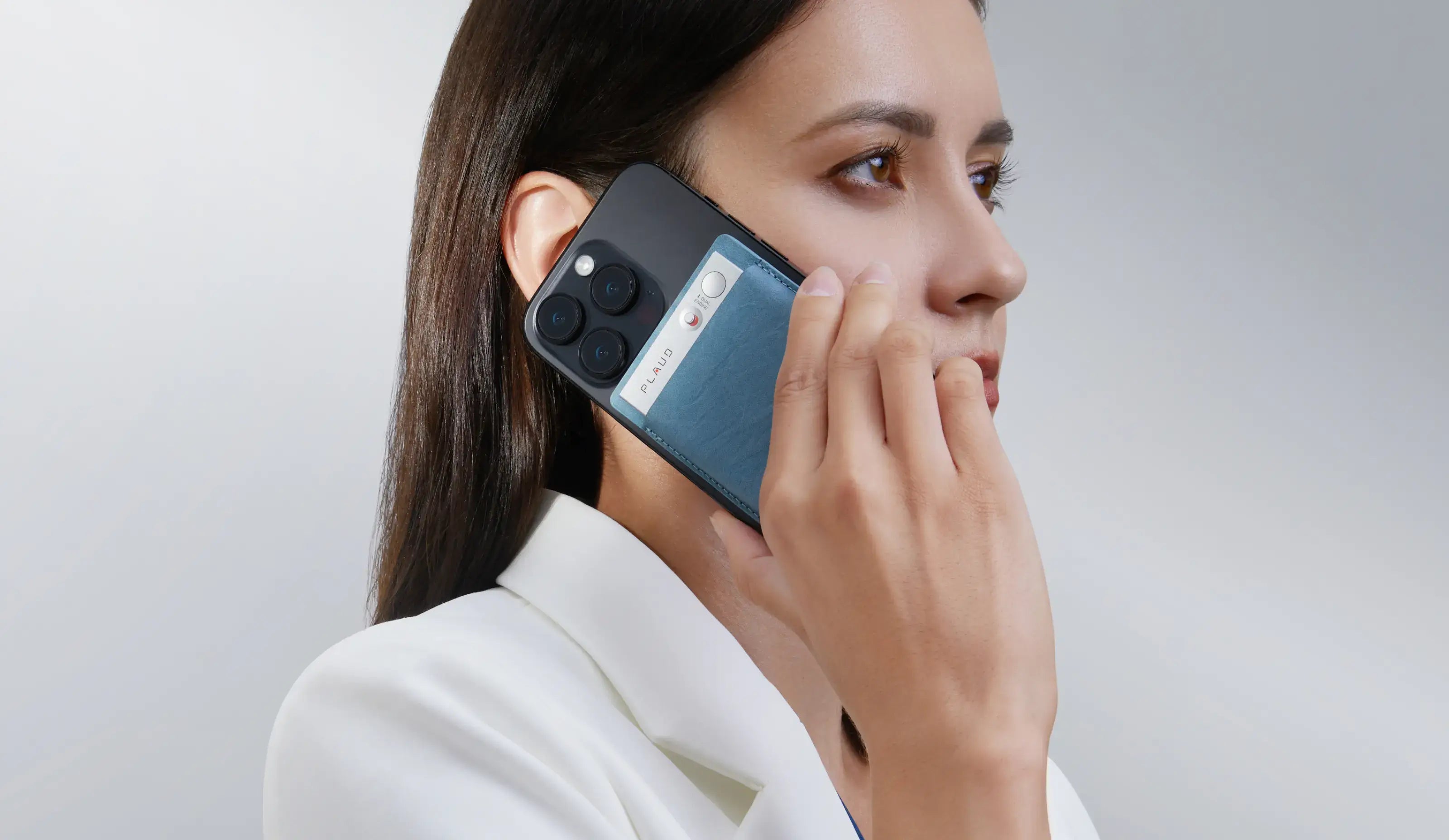 Woman holding a smartphone with a blue Plaud Note AI voice recorder attached to the back.
