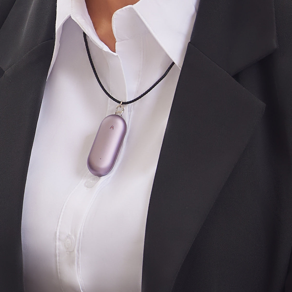 A purple PLAUD NotePin worn as a necklace over a white shirt and black blazer.