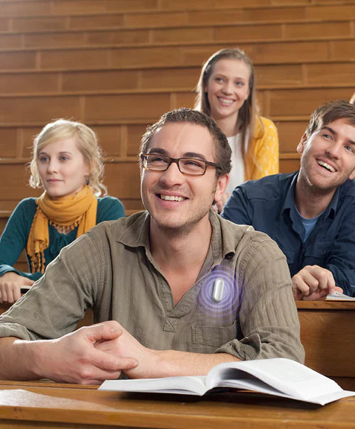 A student in a lecture hall wearing a Plaud NotePin AI voice recorder to capture and transcribe class notes.